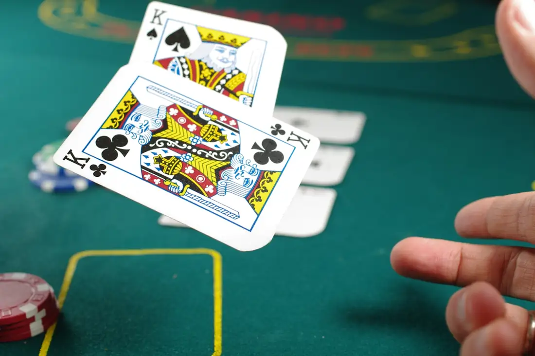 Pemain poker memegang kartu di atas meja dengan tumpukan chip